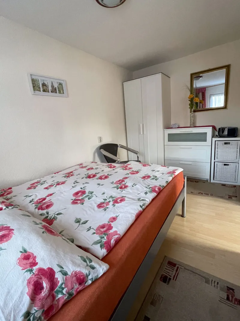 Schlafzimmer mit Kleiderschrank, Kommode und Spiegel
